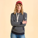 A person in a striped hoodie and red cap stands against a light beige background, arms crossed. The casual, neutral expression conveys a relaxed, confident tone.