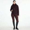 Full outfit view of model wearing LeMieux Brooke waterproof hybrid jacket in damson with riding breeches and boots