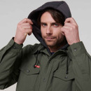 Man in a green button-up jacket pulls up a dark hood, looking confidently at the camera. Light grey background and casual outdoor attire are featured.