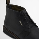 Detailed view of black leather chukka boot laces and smooth upper with subtle branding on the side.