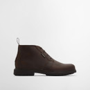Side profile of dark brown leather chukka boot with low stacked sole and clean stitched upper.