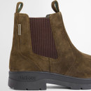 Side close-up of olive suede Chelsea boot highlighting elasticated panel and stitching detail.