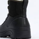 Side-rear angle of Barbour Marlow lace-up black wellington boot, highlighting pull tab and reinforced rubber heel.