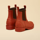 Rear angled view of Joules Oakfield orange Chelsea wellington boots with branded heel logo.