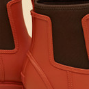 Close-up of Joules Oakfield orange wellington boot showing elastic gusset and seam detailing.