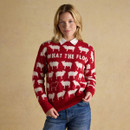 Woman wearing red ‘What The Flock’ Christmas jumper with white sheep design, styled with collared shirt and jeans.