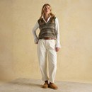 Outfit with green Fair Isle tank top layered over white blouse, styled with cream trousers.