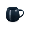 Navy blue stoneware coupe mug with Le Creuset branding, side view.