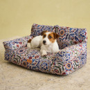 Wire Fox Terrier resting on Joules floral sofa-style dog bed with padded back support.