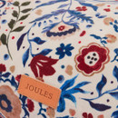 Close-up of Joules branded leather patch on floral patterned sofa-style dog bed.