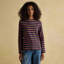 Woman wearing a navy striped long sleeve top with mustard and pink stripes, styled with blue jeans.
