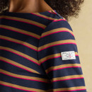 Detailed view of the Joules logo patch on the sleeve of a navy striped long sleeve top.