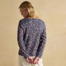 Back view of a navy ditsy floral print top with long sleeves, paired with cream trousers.