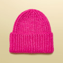 Back view of a women’s pink ribbed knit beanie hat with turn-up hem.