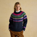 Woman wearing navy Charlie Fairisle jumper with bold fairisle design, styled with brown cord trousers.