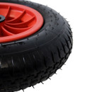 Close-up of black pneumatic tyre showing the tread pattern and red plastic wheel hub.