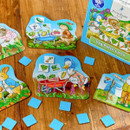 A children's board game on a wooden table features animal characters, colourful vegetable cards, and a box labelled "Veg Patch Lotto," conveying a playful tone.