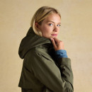 Model in Portwell coat green grapeleaf turning to side, showing hood detail.