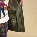 Inside view of Portwell coat in green grapeleaf showing Joules branding and checked lining.