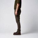 Side view of a man wearing slim-fit olive green trousers with brown boots.