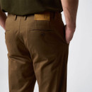 Close-up rear view of brown trousers showing welt back pockets, belt loops and a branded waistband patch.