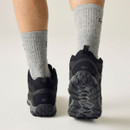 Rear view of black walking shoes in motion, highlighting the padded heels and deep multi-directional tread soles.