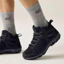 Black mid-height walking shoes with breathable mesh uppers, grey laces and rugged outdoor soles, worn with grey hiking socks.