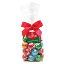 Clear bag of colorful, foil-wrapped chocolate baubles labeled "Tree Decorations," tied with a bright red bow, conveying festive cheer.