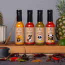 Four Edinburgh Preserves hot sauces displayed with ingredients – Barbados, Indian Naga, Jalapeño and Cajun flavours.