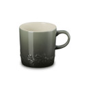 A green stoneware mug with a subtle gradient glaze and embossed holly leaves near the base, viewed from the front at an angle.