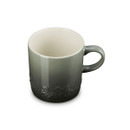 A green glazed mug with embossed holly decoration, shown at an angle from above highlighting the cream-coloured interior.