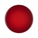 A top-down view of a Le Creuset cake stand in Cerise red with a round glossy serving surface.