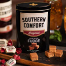 Southern Comfort Handmade Fudge 250g gift tin with creamy fudge pieces, presented with drinks in the background.
