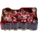 Close-up of Christmas Express train tin filled with praline chocolates wrapped in shiny red foil.