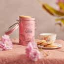Cartwright & Butler Cherry & Almond Biscuits presented in a pink clip-top tin alongside a teacup and saucer.