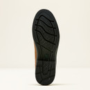 Close-up of a black shoe sole with a wavy tread pattern and textured grid design. Background is a soft cream color, emphasizing the sole's details.