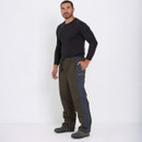 A man stands confidently against a plain white background, wearing a black long-sleeve shirt and olive-green pants with navy side panels. His expression is calm.