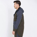 A man in profile wearing a dark, hooded jacket with a contrasting panel, standing against a white background, conveying a relaxed, casual vibe.