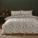 A bedroom with a reversible Halloween duvet cover showing a pumpkin, bat, moon, cobweb, and “I mean Boo!” pattern on a cream background.