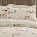 Close-up of a pillowcase from the winter bedding set, showing penguins, reindeer in knitted jumpers, and snowmen against a soft cream background.