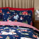 Close-up of a pillowcase from the festive bedding set, showing red houses, snowy trees, mountains, a snowman, and Christmas decorations on a navy background.