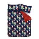 Flat-lay view of the full bedding set with pillowcases, featuring an all-over navy stocking design on one side and red snowflake print on the reverse.