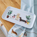 Rectangular small serving tray with illustrated dogs and potted plants, displayed on a wooden kitchen counter.