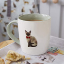 White ceramic mug with a light green handle, featuring an illustration of a Siamese cat wearing a red bow tie, from the Curious Cats collection.
