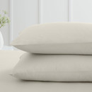 A view of a 2 pack of cream pillowcases on a bed