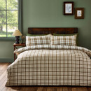 The bedding set displayed with the duvet reversed, showing the alternate plaid pattern with more muted beige and brown tones, paired with the same plaid pillowcases.