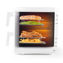 A white, multi-tray food dehydrator with four racks of food. From top to bottom: bread, green beans, fried chicken, and French fries. Warm lighting suggests cooking.