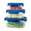 Three stacked clear containers with blue lids hold fresh vegetables: tomatoes in the top, cauliflower in the middle, and celery in the bottom.