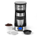 A sleek black and silver coffee maker with a digital display reading 7:15, surrounded by a stainless travel mug, coffee grounds bowl, and coffee bags.