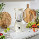 A vintage-style Salter blender sits on a marble worktop, surrounded by fresh fruits, a woven placemat, and kitchen utensils.